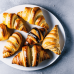 An Instagram-worthy shot of an assortment of croissants, filled and unfilled, presented on a white background