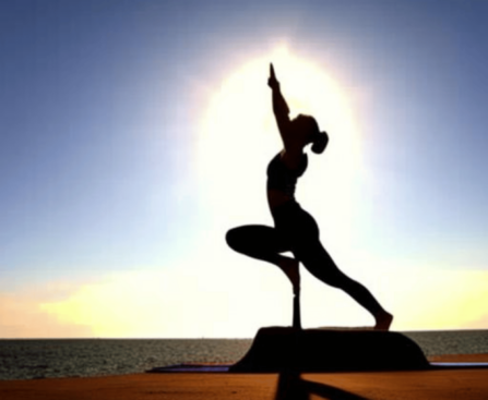 A yoga pose silhouette, such as a sun salutation or tree pose