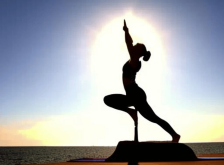 A yoga pose silhouette, such as a sun salutation or tree pose